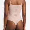 Sleeveless all-lace tank bodysuit by Tiara Galiano in dusky pink, the lace on show under an open shirt.