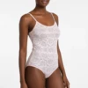Women's all-lace bodysuit in ashes of roses with a scoop neck, spaghetti straps and a thong cut.