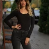 Black wool-blend bodysuit with scoop neck and long sleeves, worn alone with high-waisted trousers.