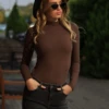 Polo-style cotton bodysuit by Tiara Galiano with covered neck and arms, warm under a coat or knit.