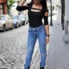 Scoop-neck cotton bodysuit with long sleeves and thong cut, a core essential worn alone with denim.