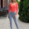 Breathable cotton bodysuit with long sleeves and hook-and-eye closure, fitted from shoulder to hip.