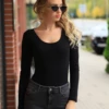 Women's long-sleeve cotton bodysuit with scoop neck and brazilian cut, a fitted everyday layer.