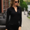 Women's cotton-blend bodysuit with thong cut and full-length sleeves, a neat polished base layer.