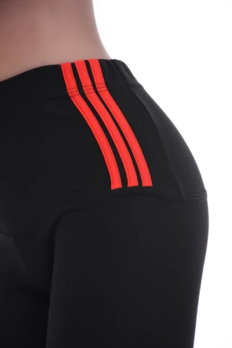 Close-up of black cotton leggings waistband with three red stripes, showing fabric texture detail