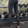 Black microfiber leggings with mesh detailing, back view in a gym setting for active training