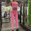 Pink high-waisted microfiber leggings, front view in a gym setting with a smooth athletic finish