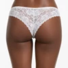 White floral lace Brazilian briefs with a front satin bow and open lower curve, a decorative low-rise cut.