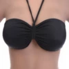 Black bandeau bikini top with a single strap crossing asymmetrically to one shoulder and a soft center gather.