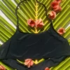 Black halter bralette bikini top with a slim neck cord and a soft scoop front, light and unpadded for comfort.
