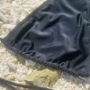 Black halter bikini top with a criss-cross lace-up at the center front that adjusts how open the deep V sits.