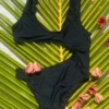 Simple black one-piece swimsuit with a subtle cutout twist, easy to wear from pool to beach bar.