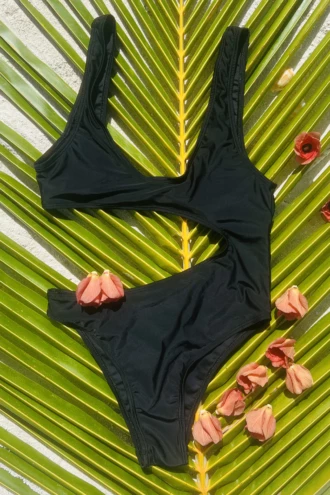 Simple black one-piece swimsuit with a subtle cutout twist, easy to wear from pool to beach bar.