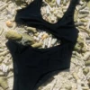 Black tank-style swimsuit with curved side cutout, tie back and a slightly cheeky back cut.
