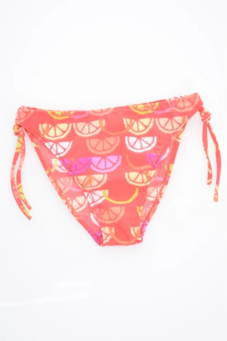 Girls' tie-side bikini bottom by Tiara Galiano in a citrus-slice print of oranges and lemons on a coral base, quick-drying polyamide.