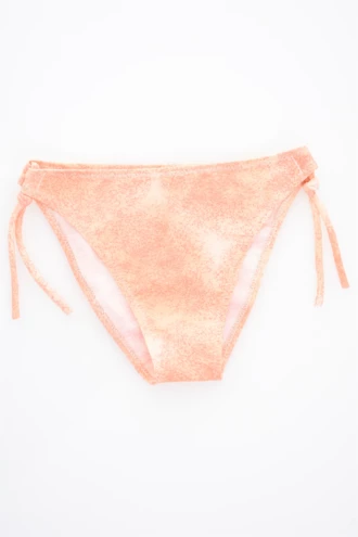 Girls' tie-side bikini bottom by Tiara Galiano in a soft washed-peach with a mottled look and matching side ties, quick-drying polyamide.