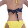 Navy dot-print bandeau bikini top worn as halter or strapless with a tie back for women.