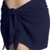 Navy microfiber sarong wrap for women, quick-drying packable one-size beach cover-up knotted low on the hips.