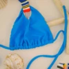 Turquoise triangle bikini top with light unpadded cups and a small multicolor tab at the center for contrast.